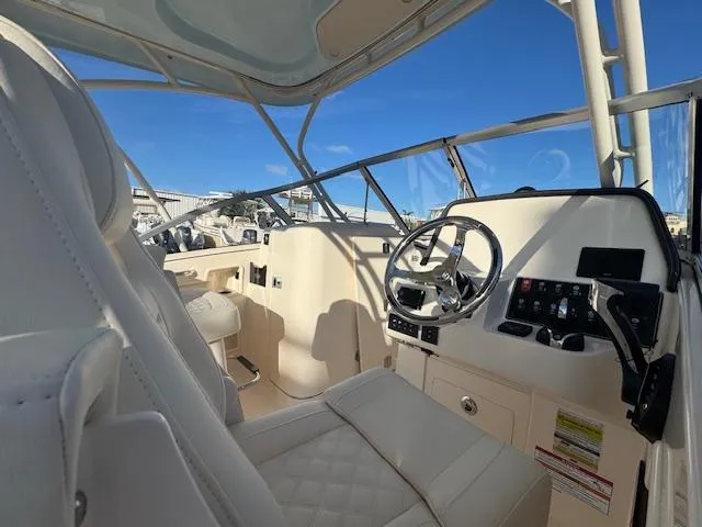 Slide: The Image of 2025 Grady-White Freedom 235 boat interior with steering wheel and seating. - 10