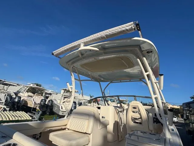 Slide: The Image of 2025 Grady-White Freedom 235 boat with seating and canopy under clear blue sky. - 4