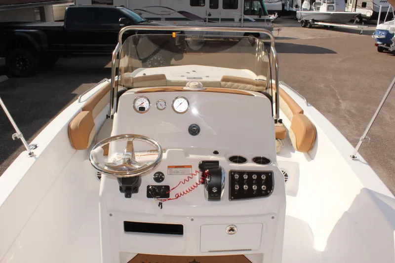 Slide: The Image of 2025 NauticStar 231 Hybrid boat dashboard with steering wheel and controls. - 16