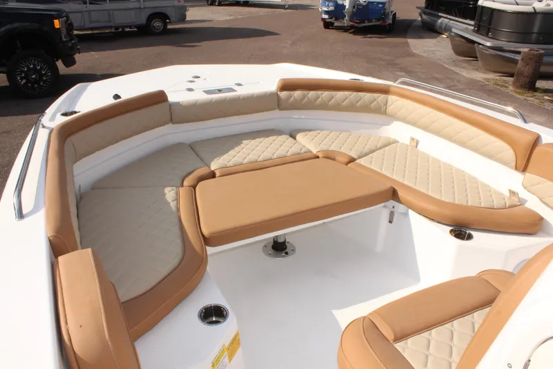 Slide: The Image of 2025 NauticStar 231 Hybrid boat with tan cushioned seating in the bow area. - 24