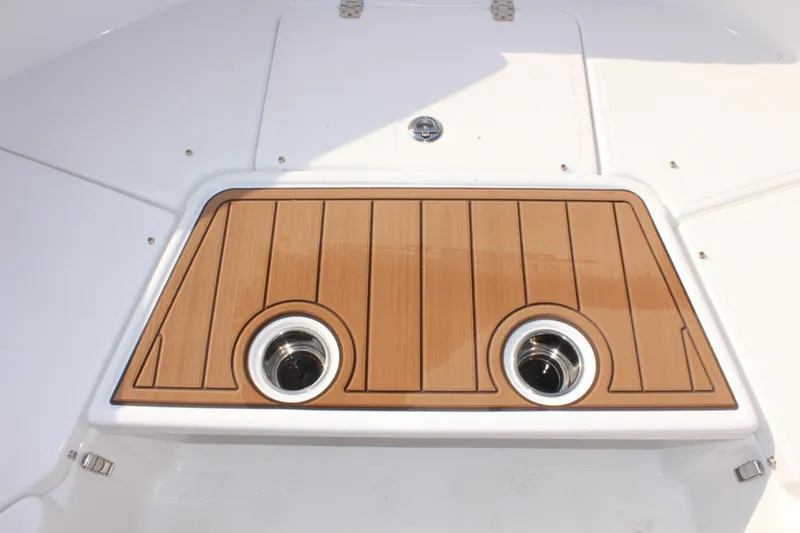 Slide: The Image of 2025 NauticStar 231 Hybrid boat deck with wood finish and cup holders. - 26
