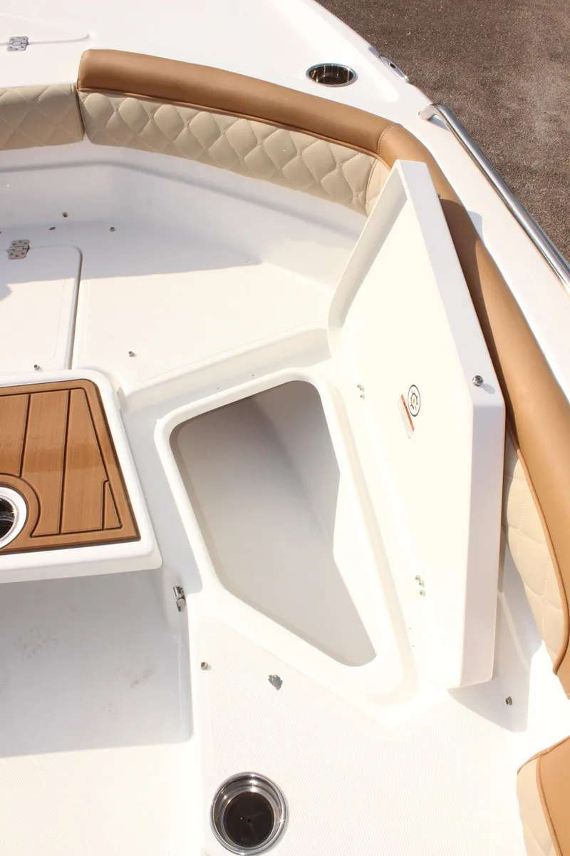 Slide: The Image of 2025 NauticStar 231 Hybrid boat interior with storage compartment and cushioned seating. - 28