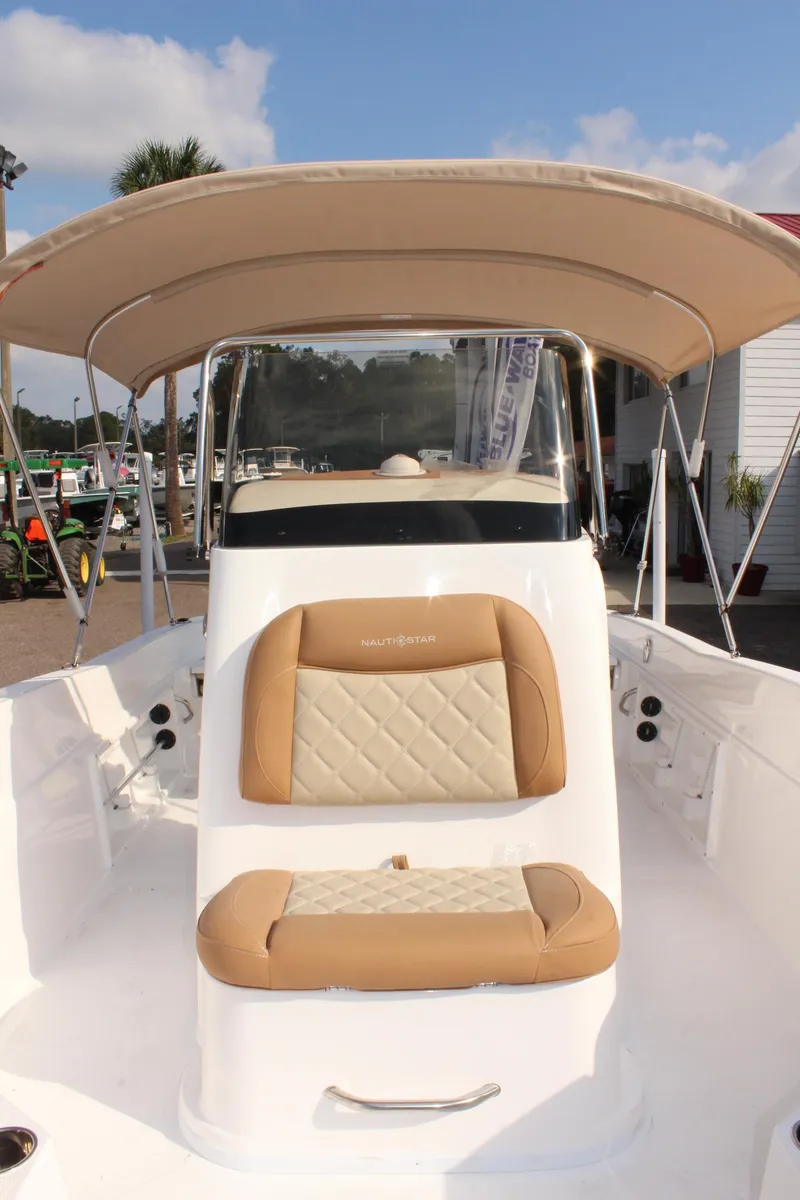 Slide: The Image of 2025 NauticStar 231 Hybrid boat with tan seating and canopy. - 31