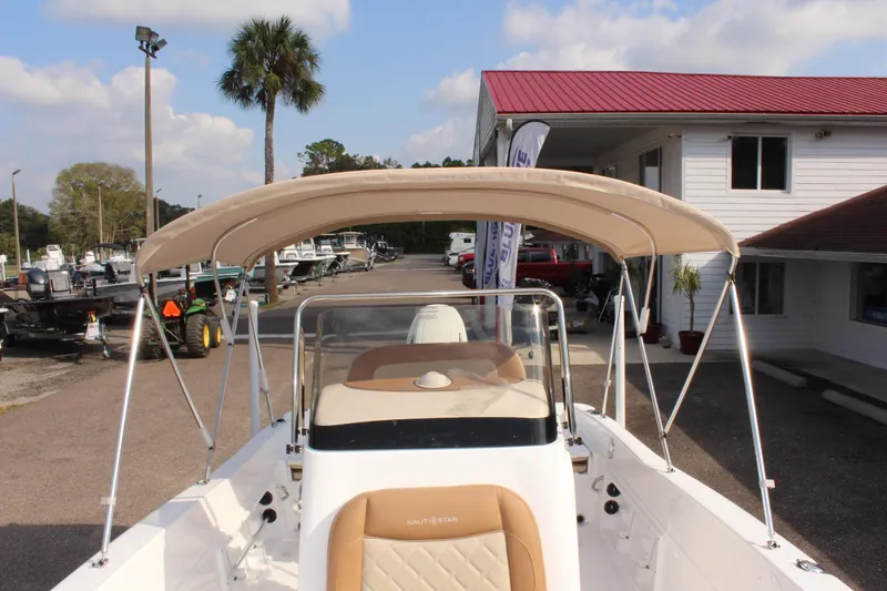 Slide: The Image of 2025 NauticStar 231 Hybrid boat with canopy, parked at a marina. - 32