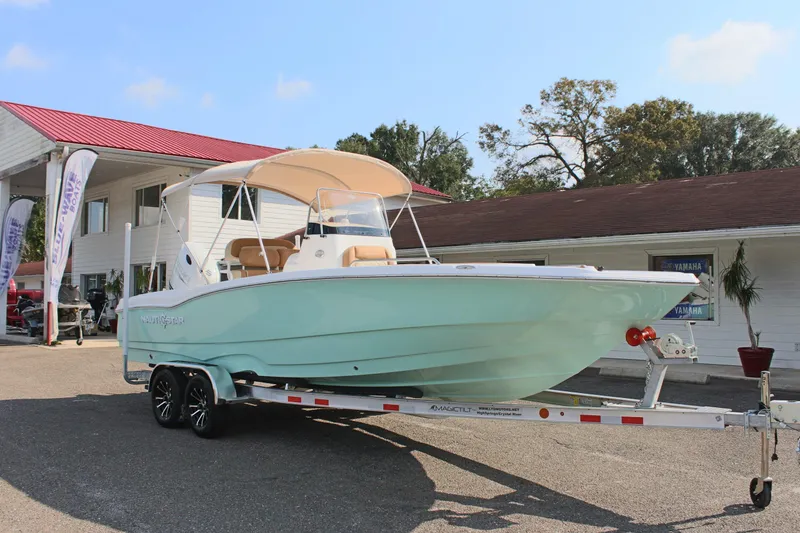 Slide: The Image of 2025 NauticStar 231 Hybrid boat on trailer, parked outdoors. - 5