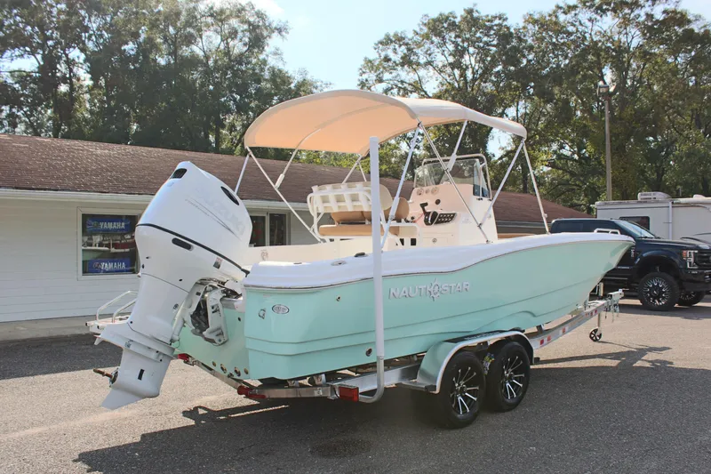 Slide: The Image of 2025 NauticStar 231 Hybrid boat on trailer, parked outdoors. - 7