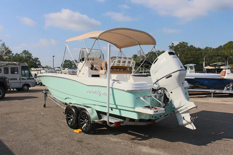Slide: The Image of 2025 NauticStar 231 Hybrid boat on trailer, mint green hull, outboard motor. - 9