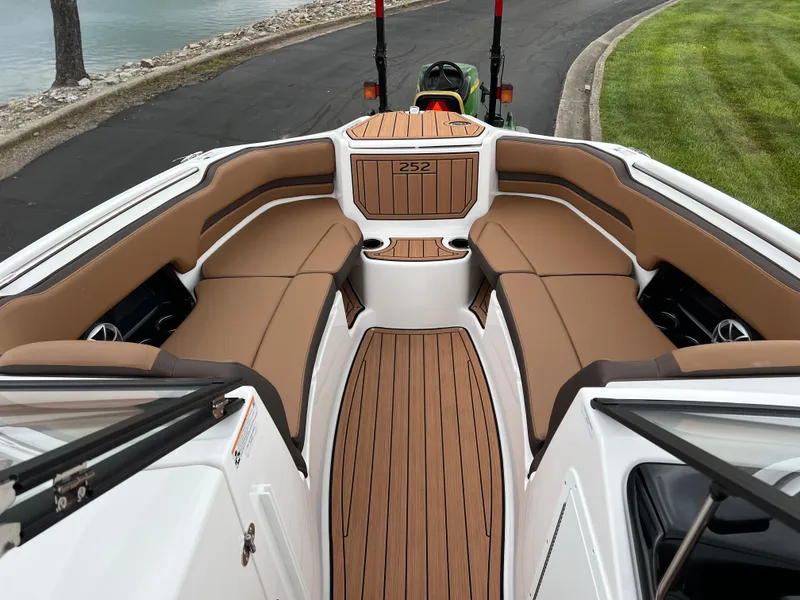 Slide: The Image of 2025 Yamaha Boats 252S interior with tan seating and wood-style flooring. - 17