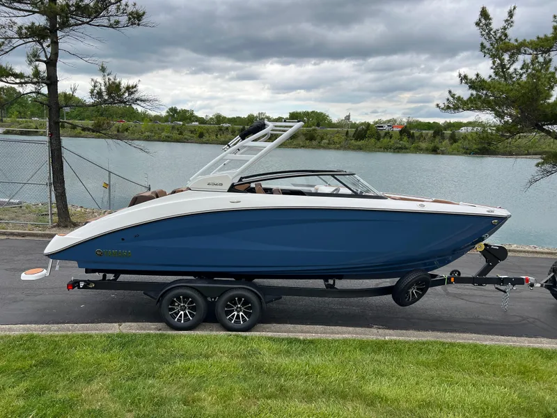 Slide: The Image of 2025 Yamaha Boats 252S on trailer by a lakeside road. - 3