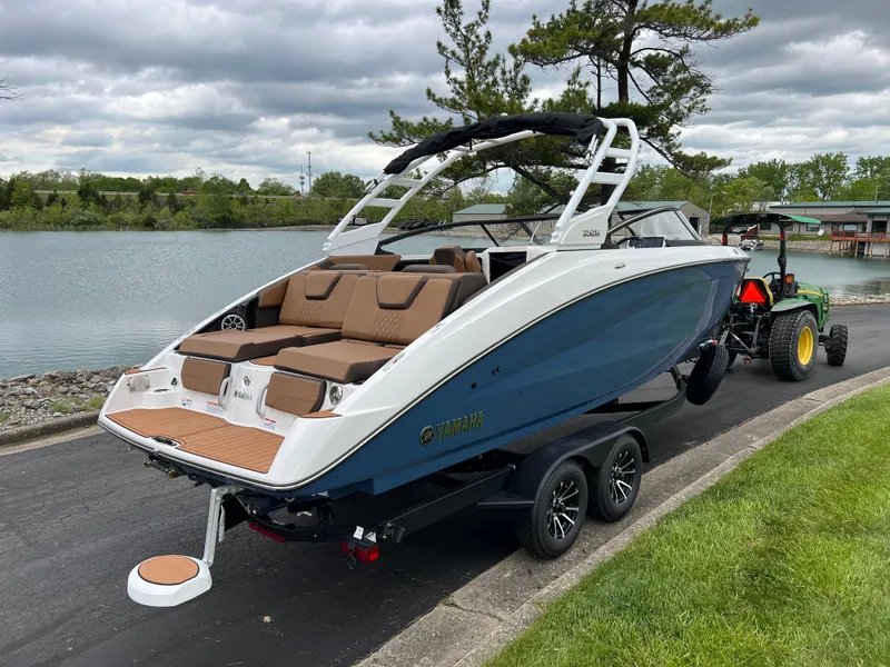 Slide: The Image of 2025 Yamaha Boats 252S on trailer by a lakeside, showcasing sleek design and modern features. - 4