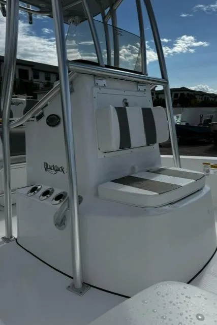 Slide: The Image of 2025 BlackJack 224 boat with seating and console, under a clear sky. - 11