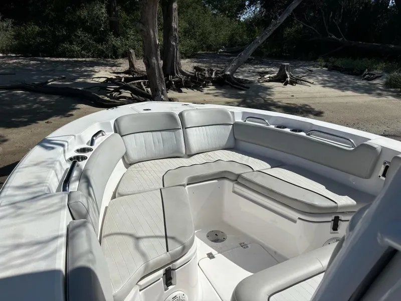 Slide: The Image of 2020 Sea Fox 228 Commander boat interior with cushioned seating, docked on a sandy shore. - 3