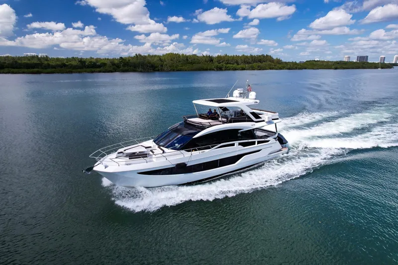 Slide: The Image of 2020 Galeon 640 Fly yacht cruising on a serene lake under a blue sky. - 5