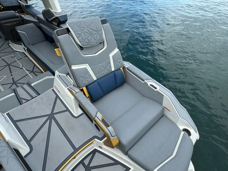 Slide: The Image of 2024 Nautique Super Air Nautique G25 Paragon luxury boat seating by the water. - 18
