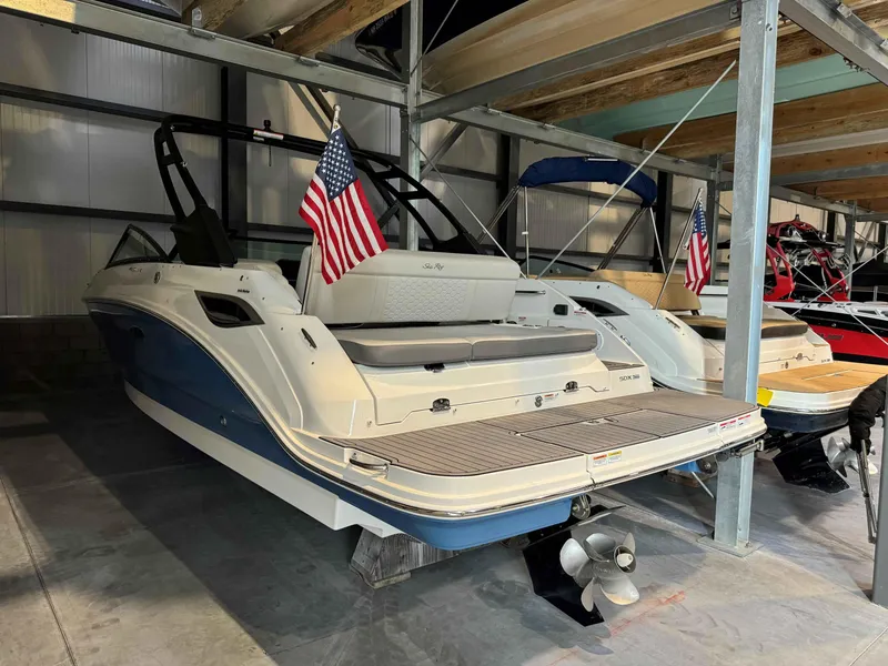 Slide: The Image of 2023 Sea Ray 250SDX boat in storage, featuring American flag and sleek design. - 3