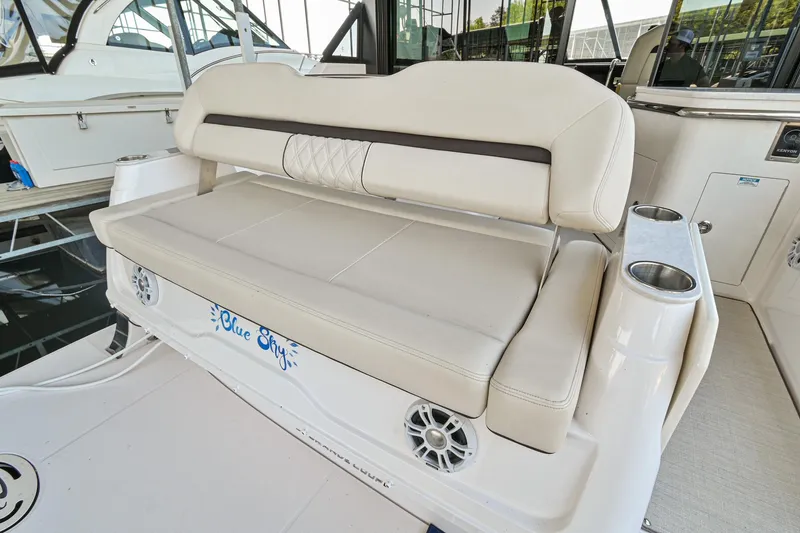 Slide: The Image of 2021 Regal 36 Grande Coupe boat seating area with speakers and cup holders. - 12