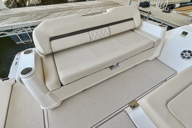 Slide: The Image of 2021 Regal 36 Grande Coupe boat seating with beige upholstery and cup holders. - 14