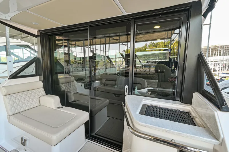Slide: The Image of 2021 Regal 36 Grande Coupe yacht interior with seating and sliding glass doors. - 19
