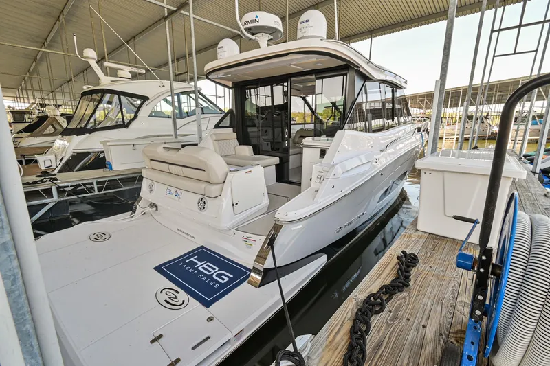 Slide: The Image of 2021 Regal 36 Grande Coupe yacht docked in a marina under a covered structure. - 7