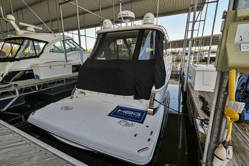 Slide: The Image of 2021 Regal 36 Grande Coupe docked in a marina under a covered slip. - 9