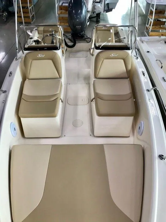 Slide: The Image of 2025 Scout 175 Sport Dorado boat interior with beige seating and dual consoles. - 8