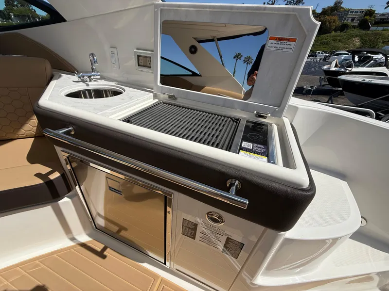 Slide: The Image of Outdoor kitchenette on 2025 Sea Ray Sundancer 320 OB with sink and grill. - 10
