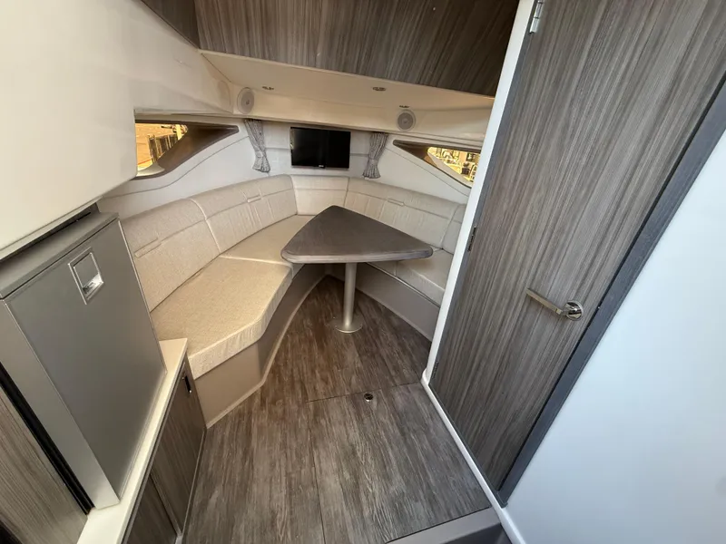 Slide: The Image of 2025 Sea Ray Sundancer 320 OB cabin interior with modern seating and table. - 18