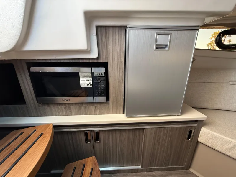 Slide: The Image of 2025 Sea Ray Sundancer 320 OB interior with microwave and compact fridge. - 20
