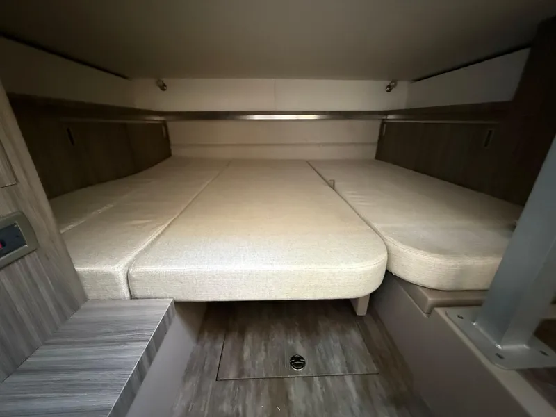 Slide: The Image of 2025 Sea Ray Sundancer 320 OB cabin interior with beige bedding and modern wood accents. - 21
