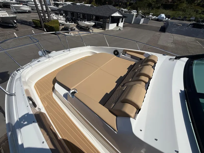 Slide: The Image of 2025 Sea Ray Sundancer 320 OB with spacious sunbathing deck in marina setting. - 24