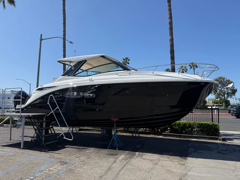 Slide: The Image of 2025 Sea Ray Sundancer 320 OB boat displayed outdoors on a sunny day. - 4