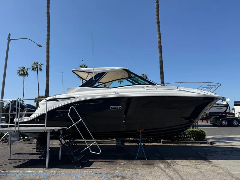 Slide: The Image of 2025 Sea Ray Sundancer 320 OB boat displayed outdoors under clear blue sky. - 5