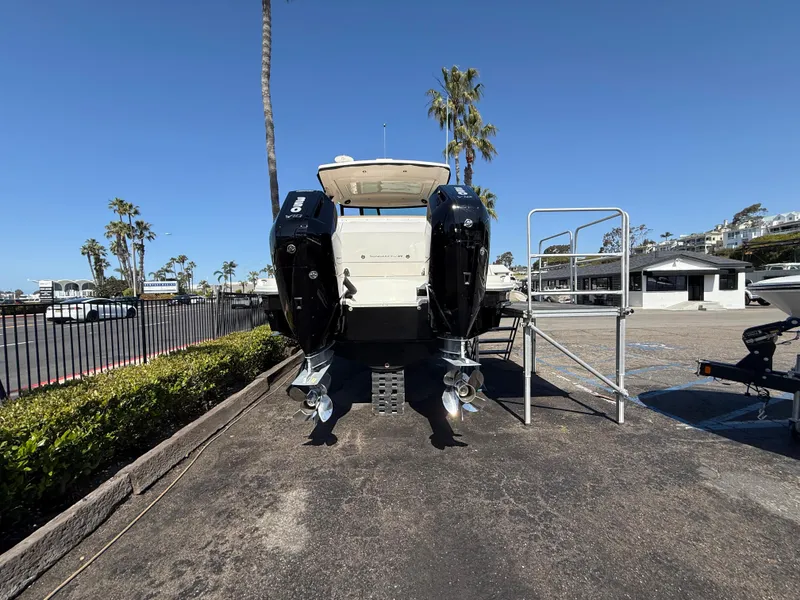 Slide: The Image of 2025 Sea Ray Sundancer 320 OB boat with dual outboard engines, parked on a sunny day. - 6