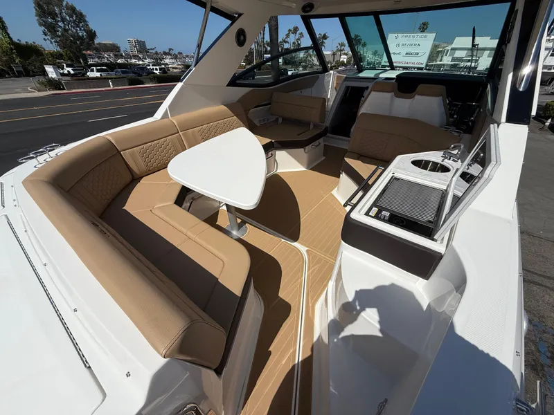 Slide: The Image of 2025 Sea Ray Sundancer 320 OB interior with tan seating and modern amenities. - 7