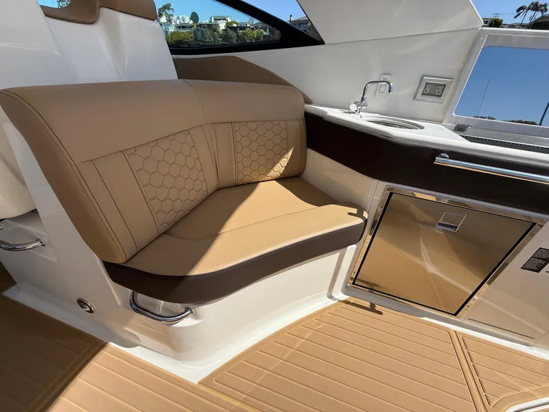 Slide: The Image of Luxurious interior of 2025 Sea Ray Sundancer 320 OB with tan seating and kitchenette. - 9