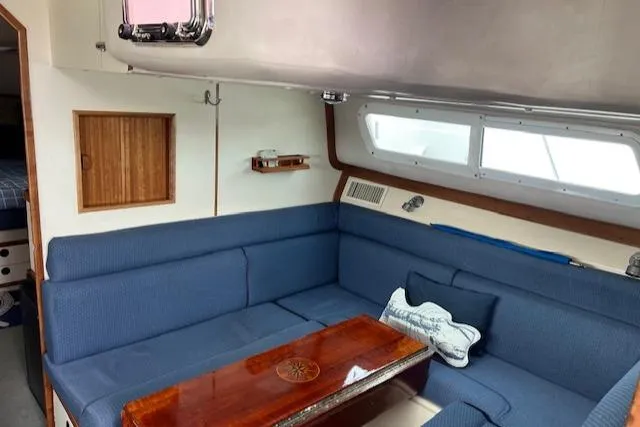 Slide: The Image of Interior of 2003 Albin 32 + 2 Command Bridge with blue seating and wooden table. - 11