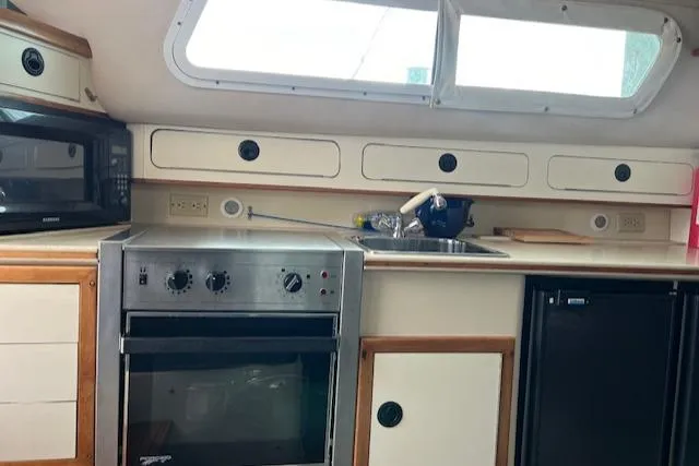 Slide: The Image of Interior of 2003 Albin 32 + 2 Command Bridge with kitchen appliances and storage. - 12