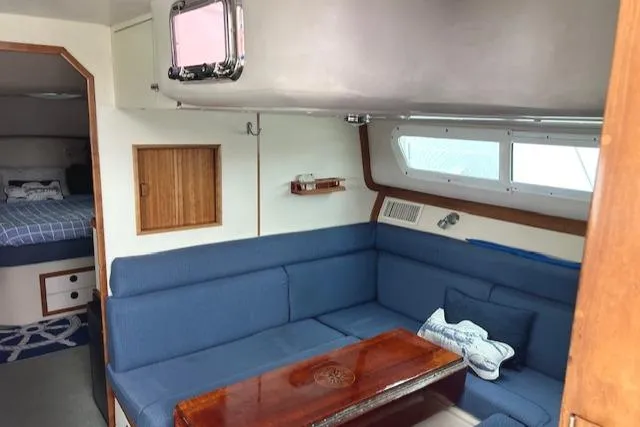 Slide: The Image of Interior of 2003 Albin 32 + 2 Command Bridge with blue seating and wooden table. - 13