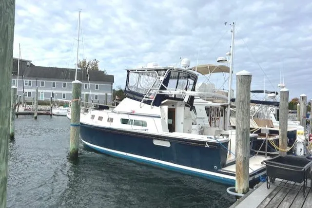 Slide: The Image of 2003 Albin 32 + 2 Command Bridge docked at marina under cloudy sky. - 4