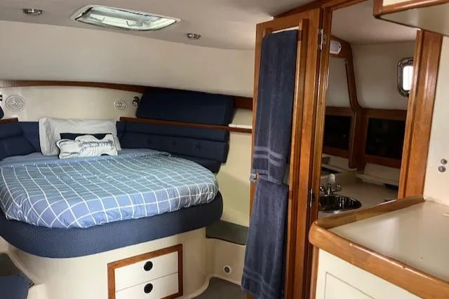 Slide: The Image of Interior of 2003 Albin 32 + 2 Command Bridge with cozy bed and wooden cabinetry. - 7
