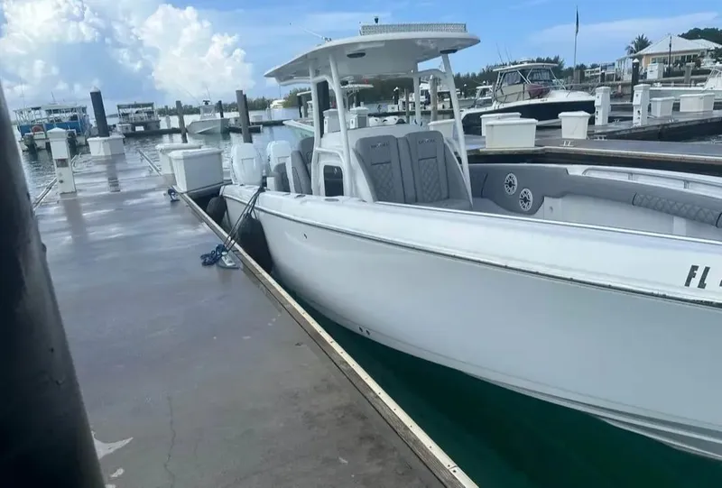 Slide: The Image of 2007 Donzi 35 ZF Open boat docked at marina under cloudy sky. - 11