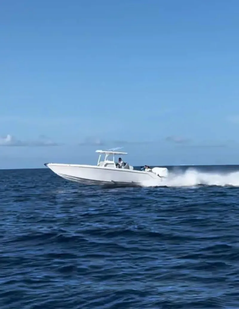 Slide: The Image of 2007 Donzi 35 ZF Open speedboat cruising on open ocean under clear blue sky. - 2