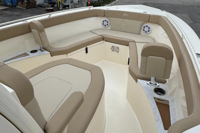 Slide: The Image of 2025 Scout 240 XSF boat interior with beige seating and cup holders. - 2