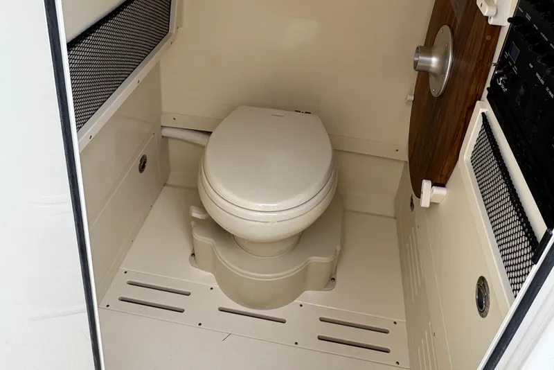 Slide: The Image of 2025 Scout 240 XSF boat interior with compact marine toilet. - 6