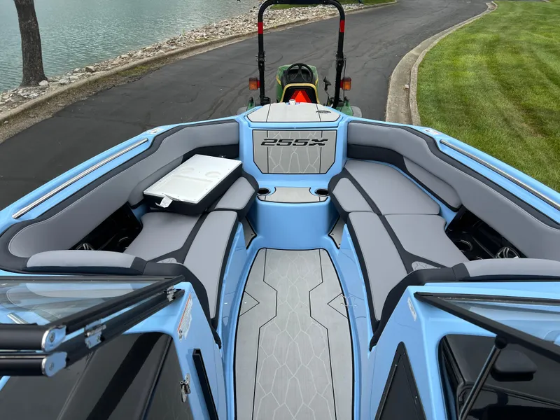 Slide: The Image of 2025 Yamaha Boats 255XD interior, featuring sleek seating and modern design by the water. - 14