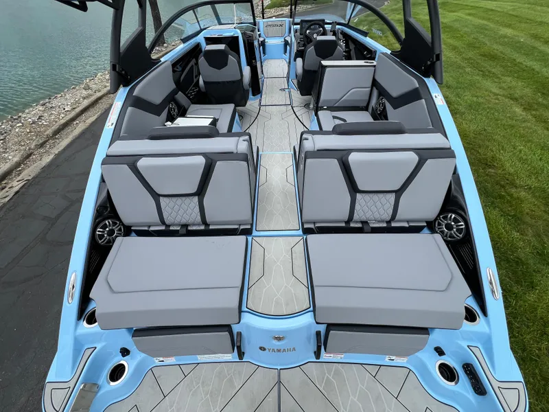 Slide: The Image of 2025 Yamaha Boats 255XD interior with sleek seating and modern design by the water. - 6