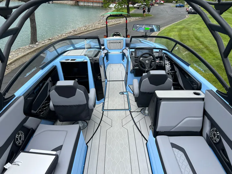 Slide: The Image of 2025 Yamaha Boats 255XD interior, featuring modern seating and sleek design by a lakeside. - 8