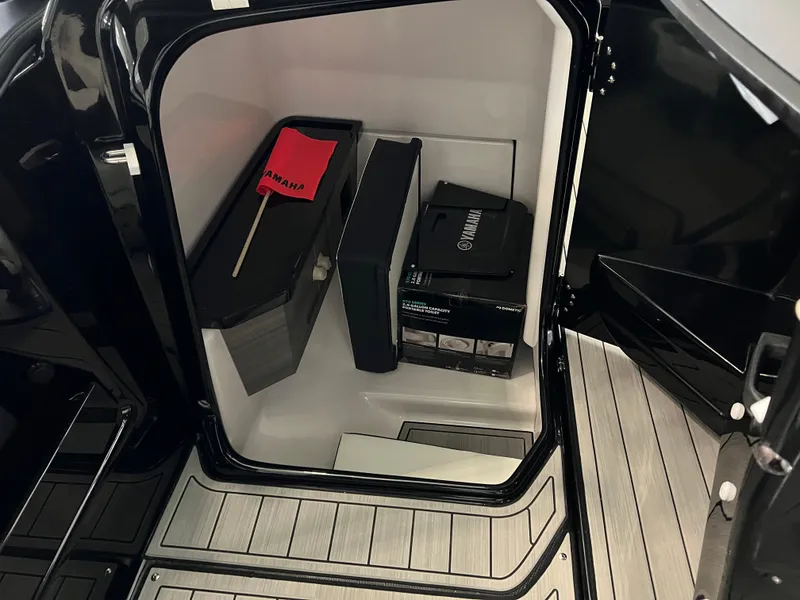 Slide: The Image of Storage compartment in 2025 Yamaha Boats 275 SD, featuring safety equipment and accessories. - 12