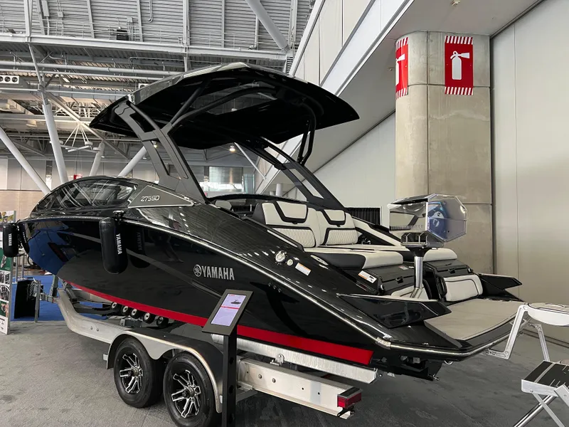 Slide: The Image of 2025 Yamaha Boats 275 SD, sleek black design, displayed indoors on a trailer. - 3