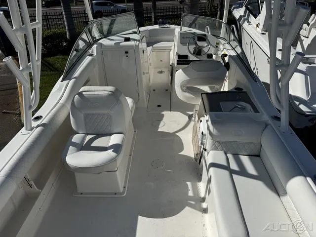 Slide: The Image of 2025 Key West 239 DFS boat interior with seating and console, parked outdoors. - 11